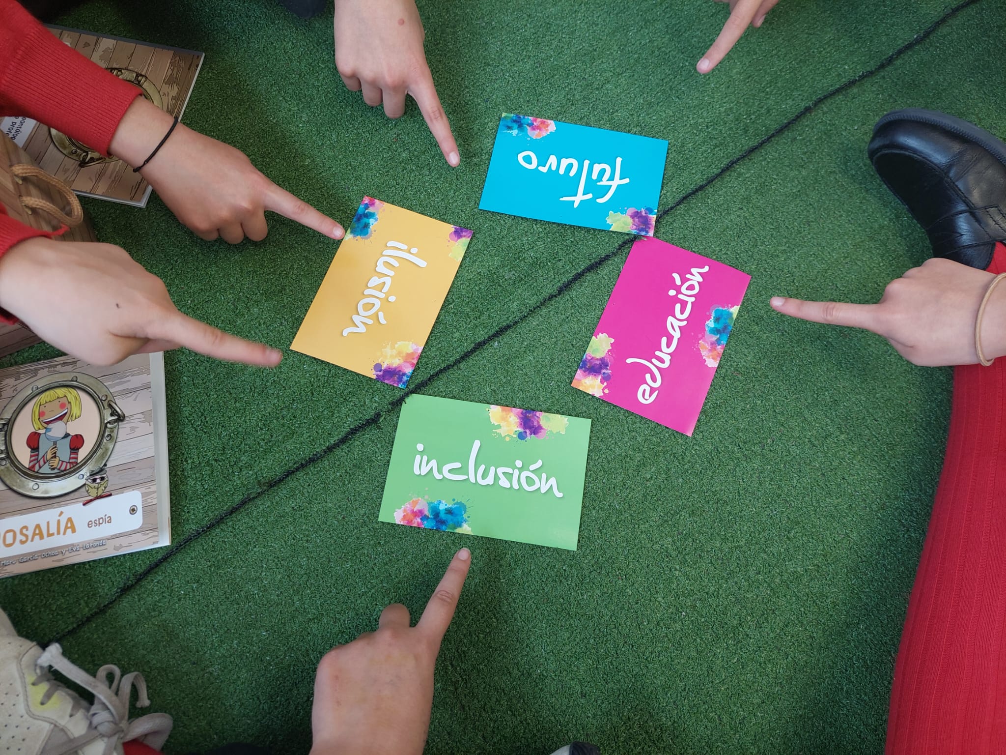 Estudiantes señalando unas tarjetas con las palabras inclusión, ilusión, futuro y educación