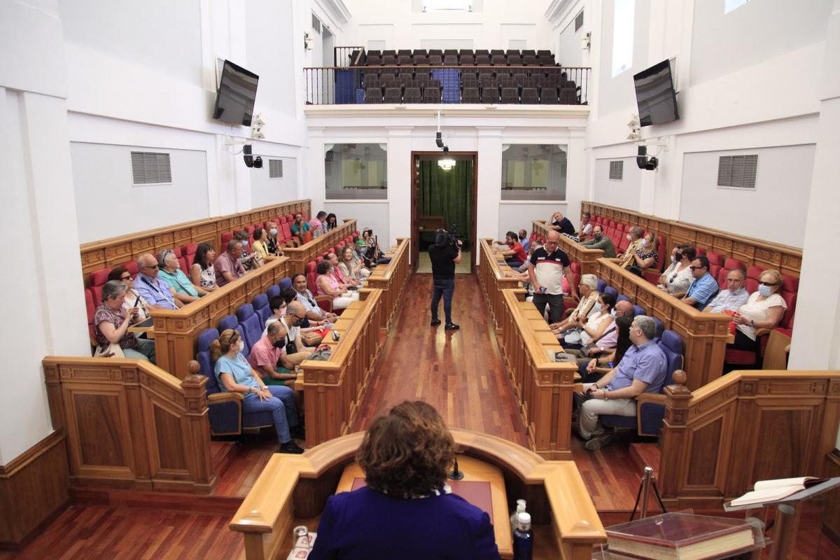Afiliados y Trabajadores ONCE sentados en el Salón de Pleno de las Cortes Regionales