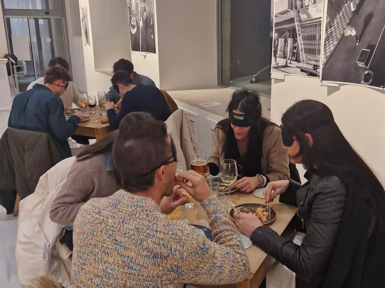 Personas con el antifaz disfrutando de la cena a ciegas