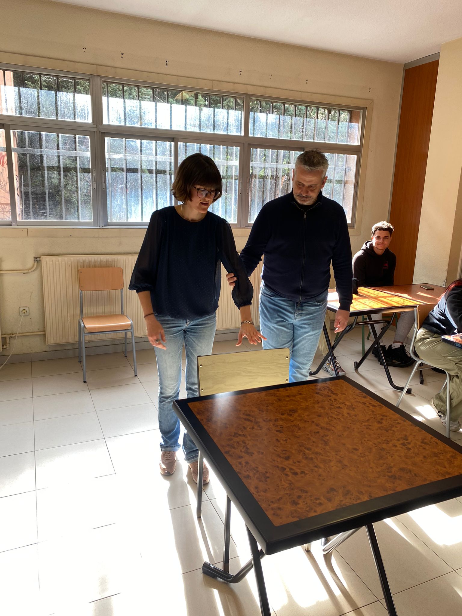 Elvira Asensio, técnica de rehabilitación de la ONCE, mostrando cómo guiar a una persona ciega para sentarse en la mesa