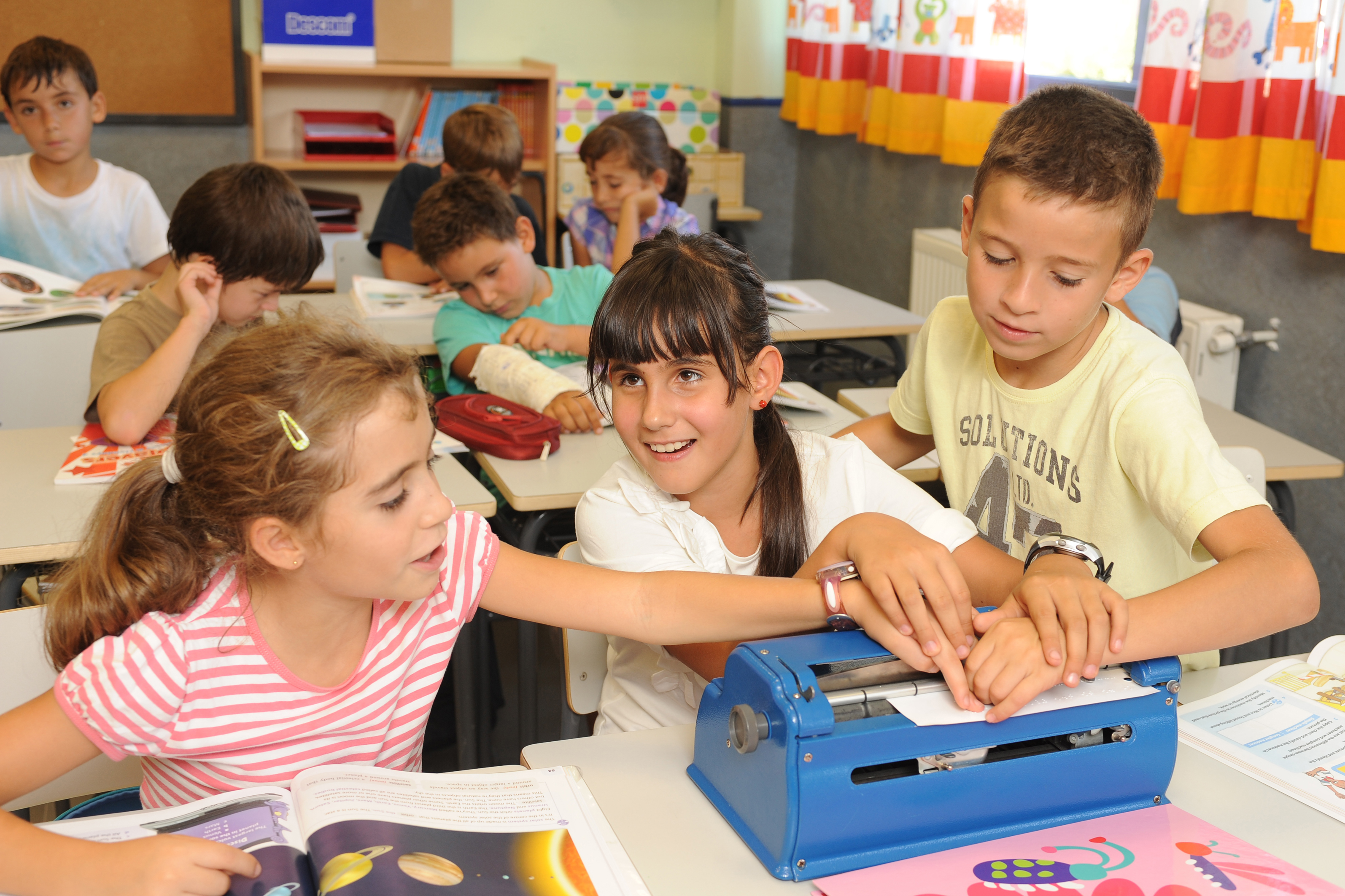 Alumnos con discapacidad visual en clase utilizando la máquina perkins