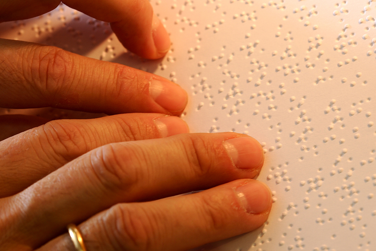 Detalle de unas manos leyendo braille