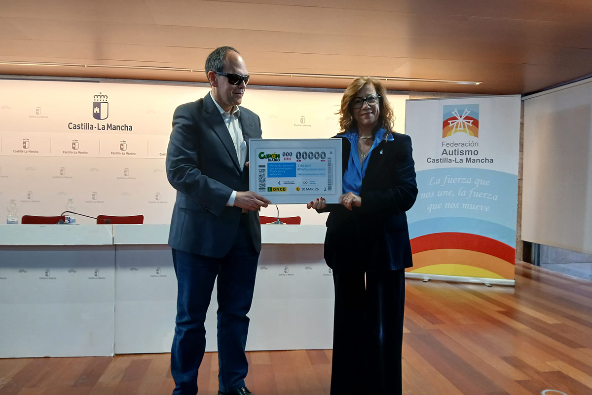 José Martínez, presidente del Consejo Territorial de la ONCE en Castilla-La Mancha, entregando una imagen del cupón a la presidente de la Federación de Autismo de Castilla-La Mancha y presidenta del CERMI CLM, Cristina Gomez