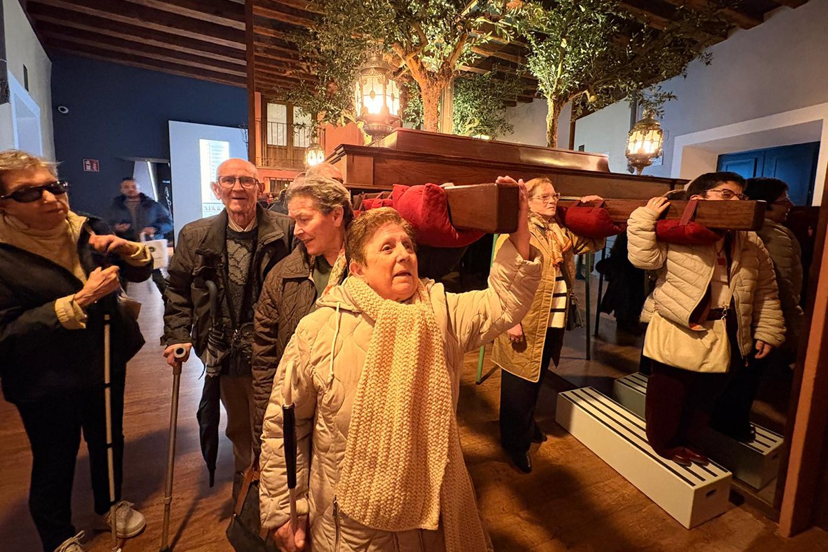 Participantes de la visita tocando un trono de semana santa
