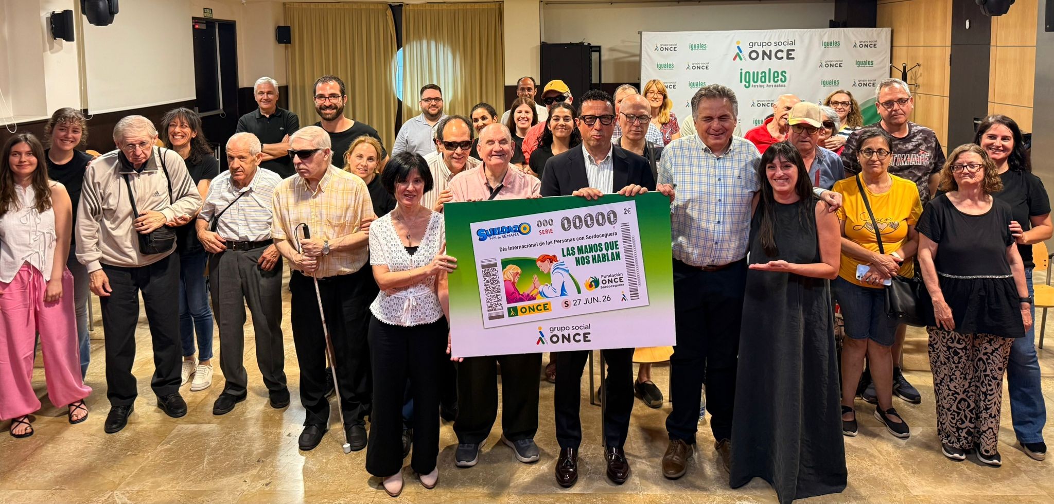 Foto de familia de los participantes con una imagen del cupón