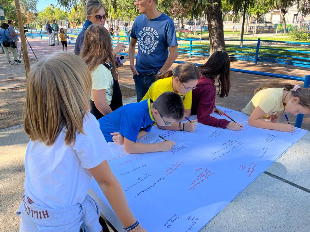 Participantes de la actividad escribiendo en una cartulina su experiencia