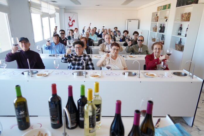 Participantes de la cata de vinos con sus copas alzadas brindando