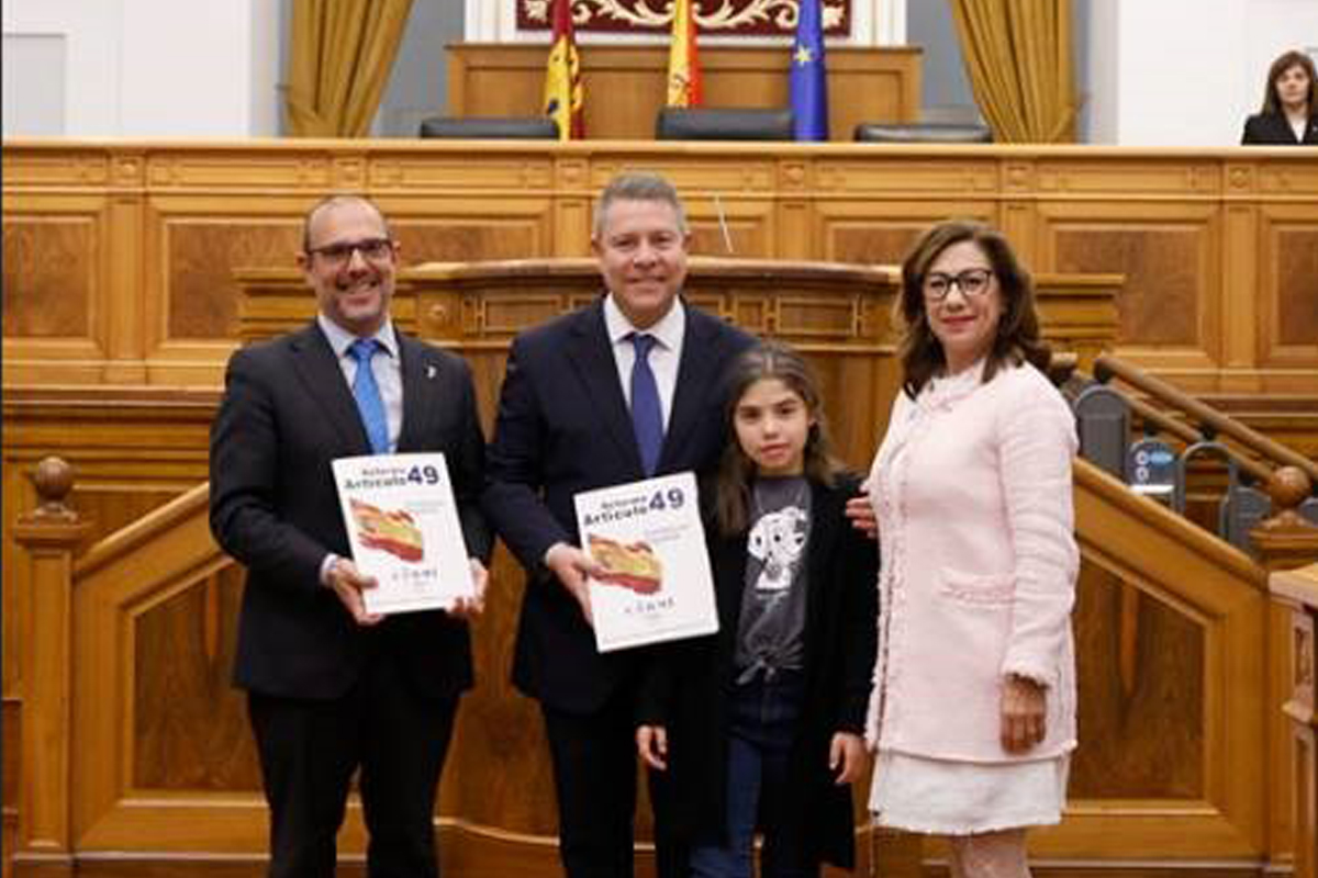 De izquierda a derecha, el presidente de la Cortes, Pablo Bellido; del presidente de la Junta, Emiliano García Page; Eva Morales, alumna con discapacidad visual; y la presidenta del CERMI de Castilla-La Mancha, Cristina Gómez en el acto de entrega del artículo 49