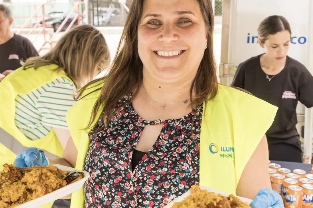 Trabajadora de llunion durante la jornada celebrada repartiendo platos de paella