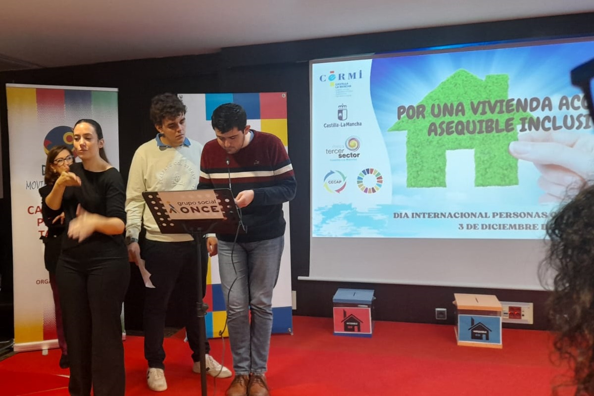 Dos jóvenes en el acto del CERMI CLM reclamando una vivienda digna y adecuada como derecho fundamental para la vida independiente de las personas con discapacidad