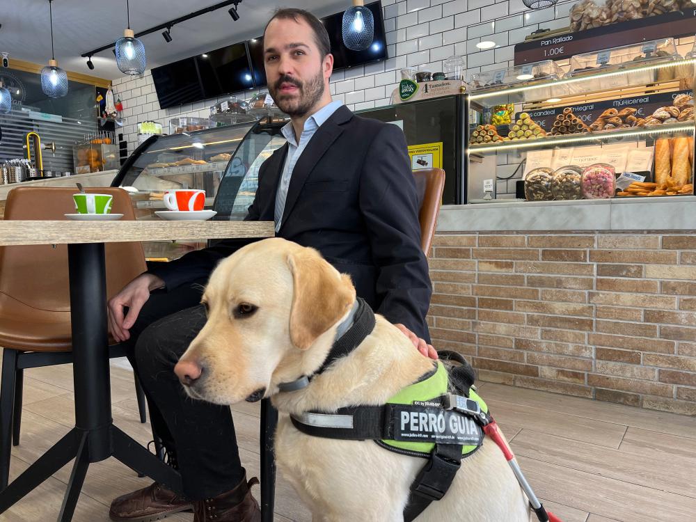 Un usuario de perro guía en una cafetería