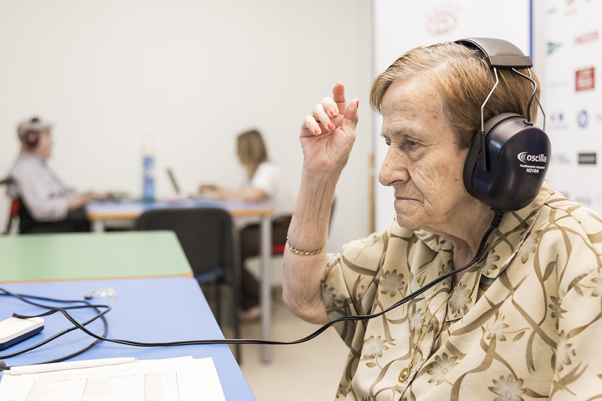 Una mujer de la residencia de Ilunion con unos cascos durante la revisión de su salud auditiva