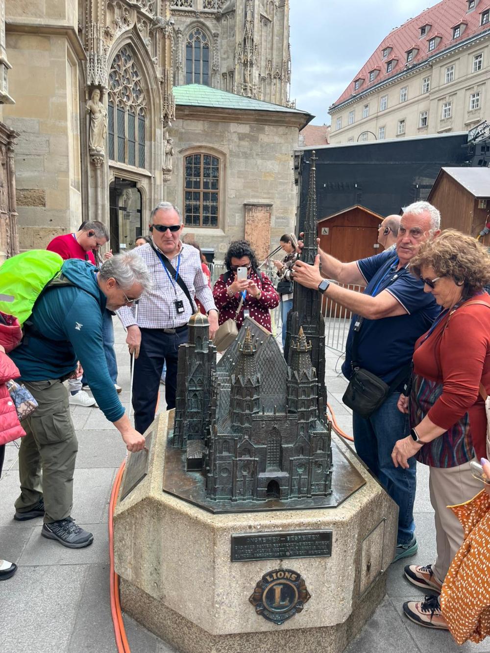 Participantes del viaje tocando una maqueta accesible en el centro de Viena