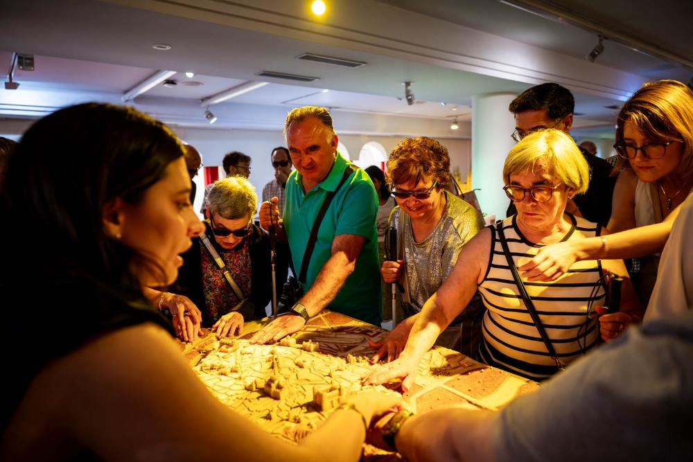 Personas con sordoceguera de Castilla-La Mancha tocan una de las maquetas del Museo Tiflológico de la ONCE