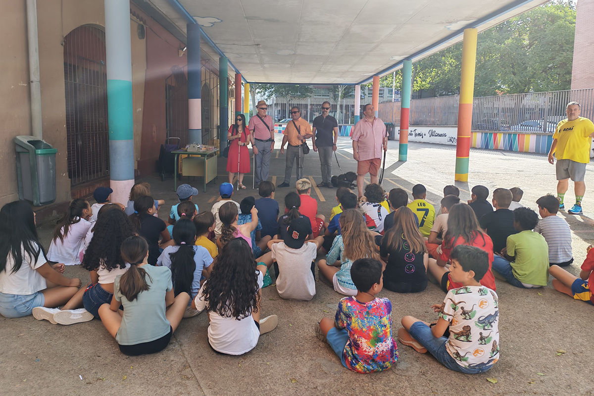 Uno de los talleres de sensibilización en los que Lorenzo Villahermosa, David Enrique con su perro guía y varios voluntarios de la ONCE hablando a los niños y niñas