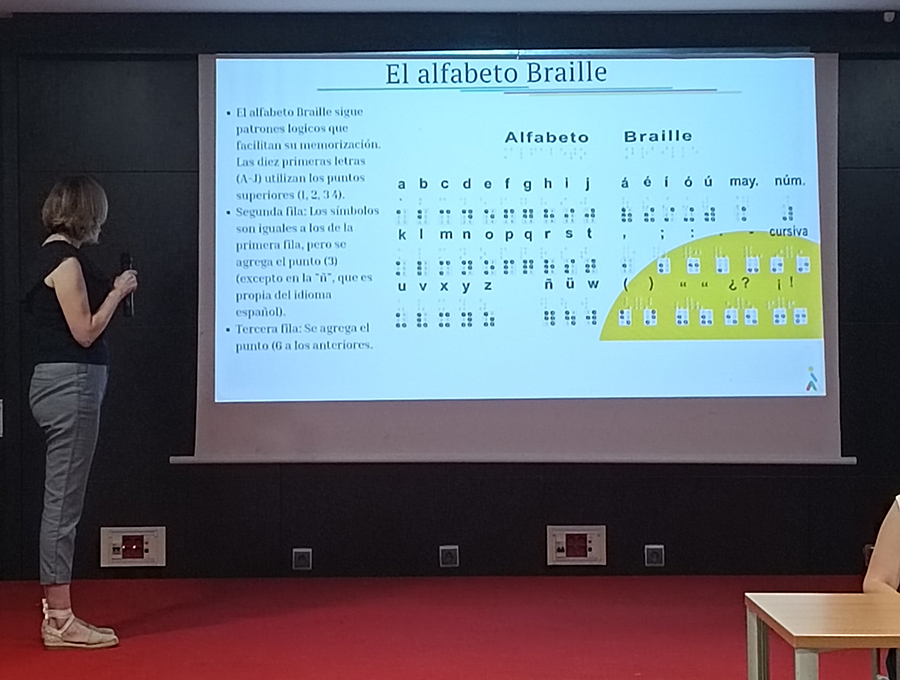 Lourdes Bullido explicando el alfabeto braille en la presentación del Informe de Valor Compartido
