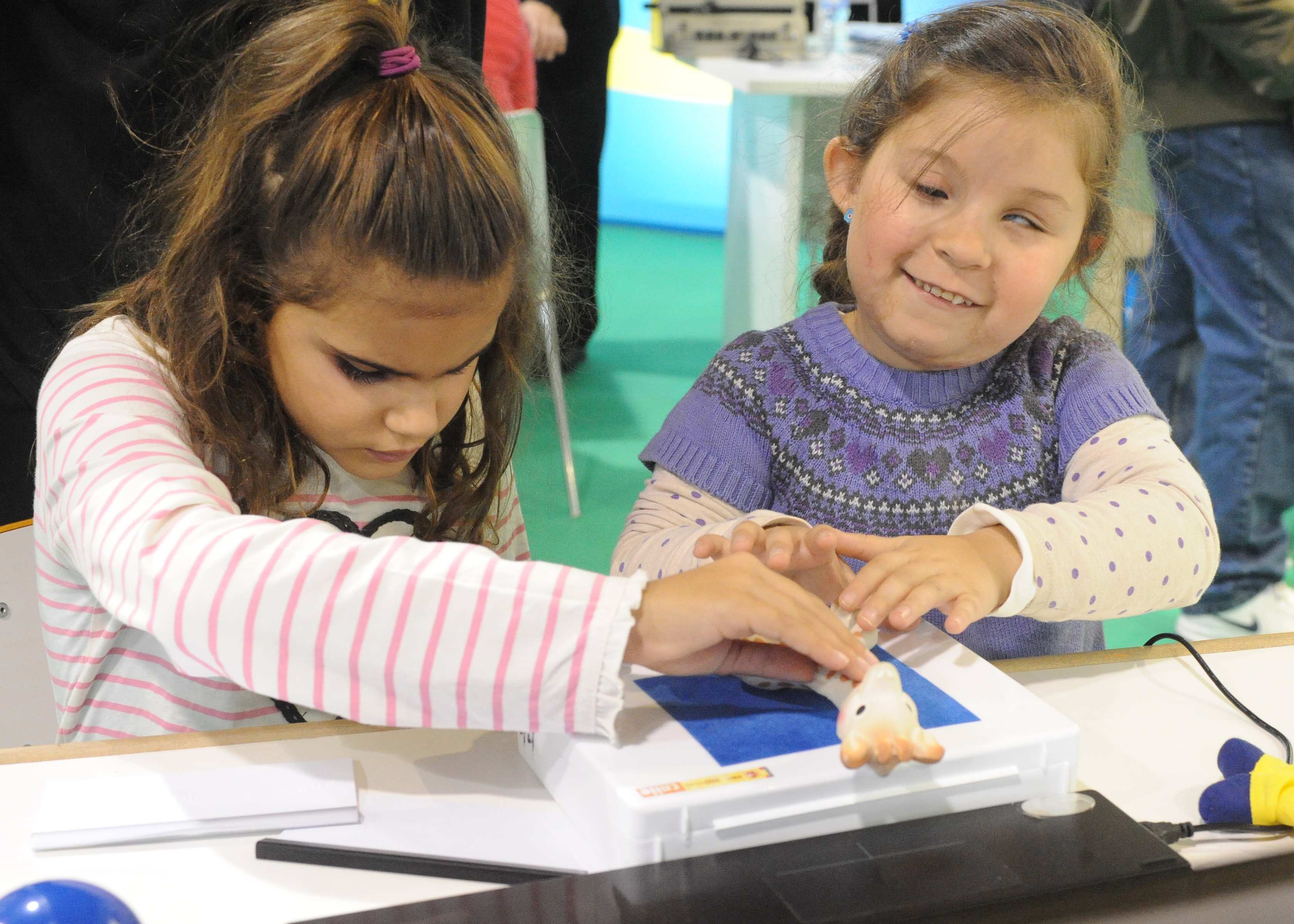 Dos alumnas con discapacidad visual tocando un libro en relieve
