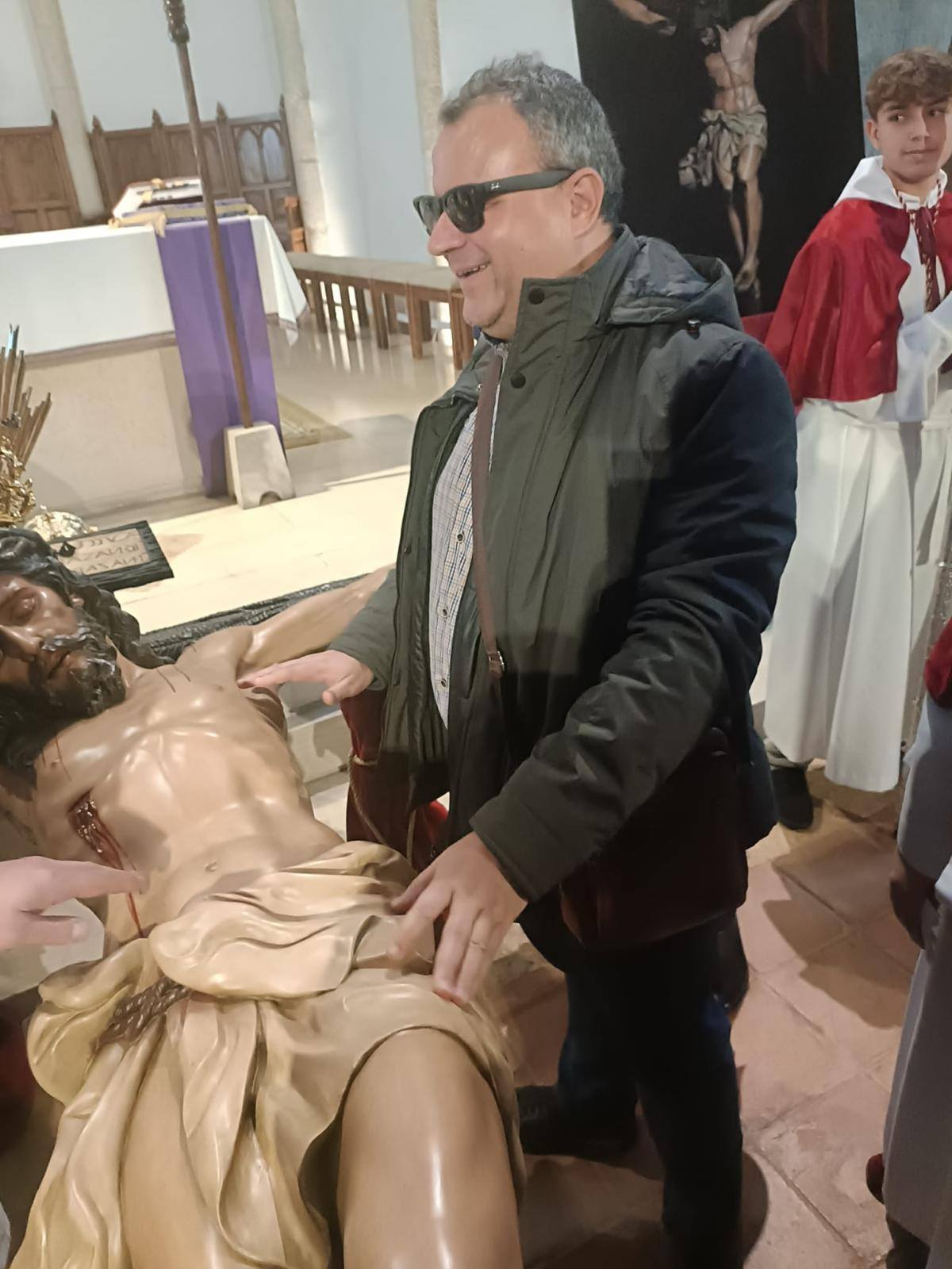 Lorenzo Villahermosa tocando la imagen del Cristo de la Caridad