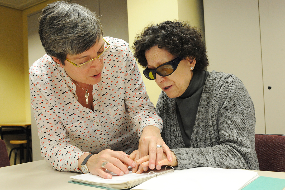 Una profesora de braille enseña a leer con las manos a una mujer ciega