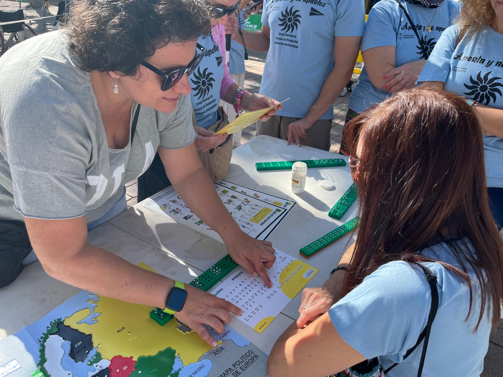 Una mujer en el stand de la ONCE conociendo el braille